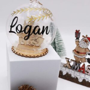 Boules de Noël sujet en bois en verre avec son décors et avec le prénom d'un membre de votre famille. Une belle idée de décoration pour son sapin.